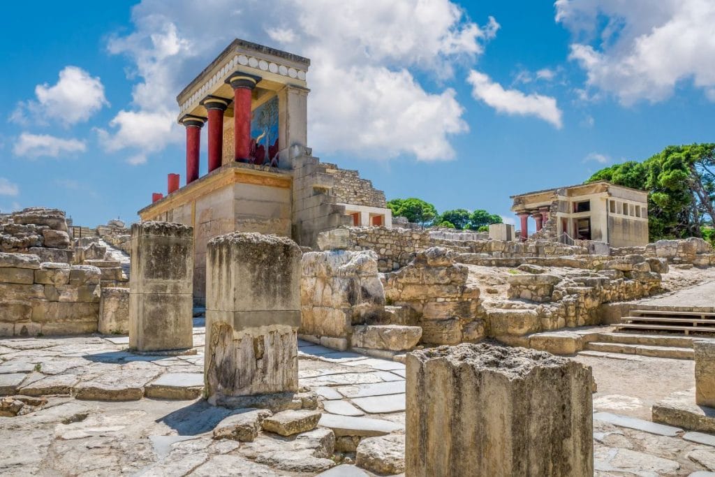 Restored red columns and stone ruins at Knossos Palace in Crete